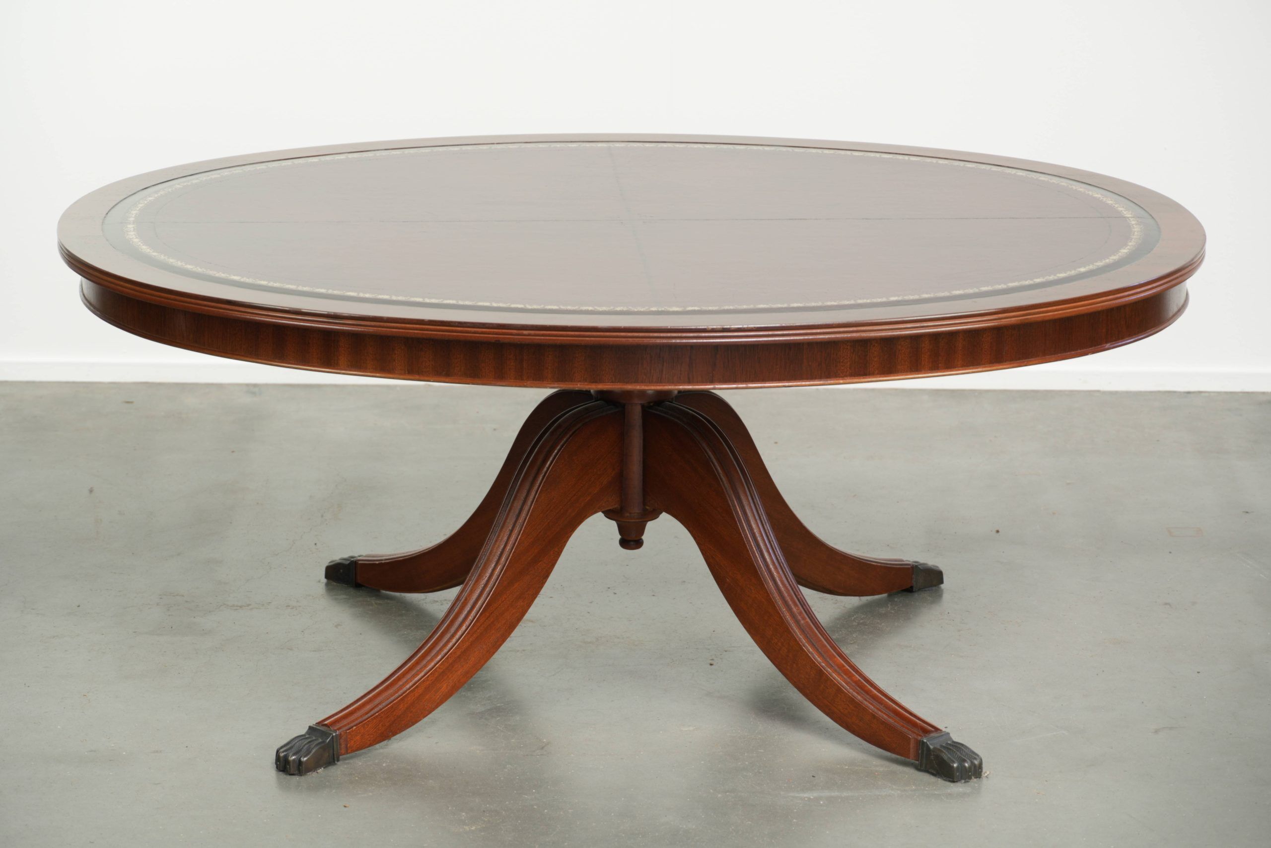 Table basse avec un plateau en cuir rouge de style anglais du 20e siècle.