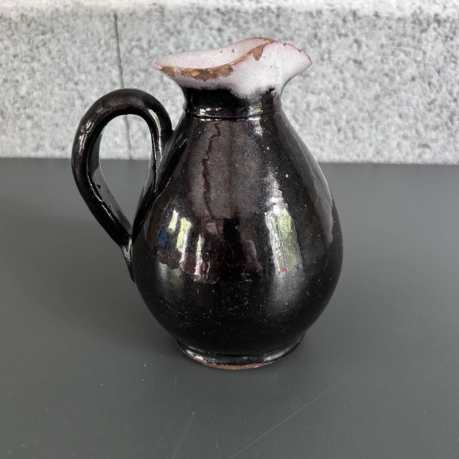 Antique black pitcher with white collar
