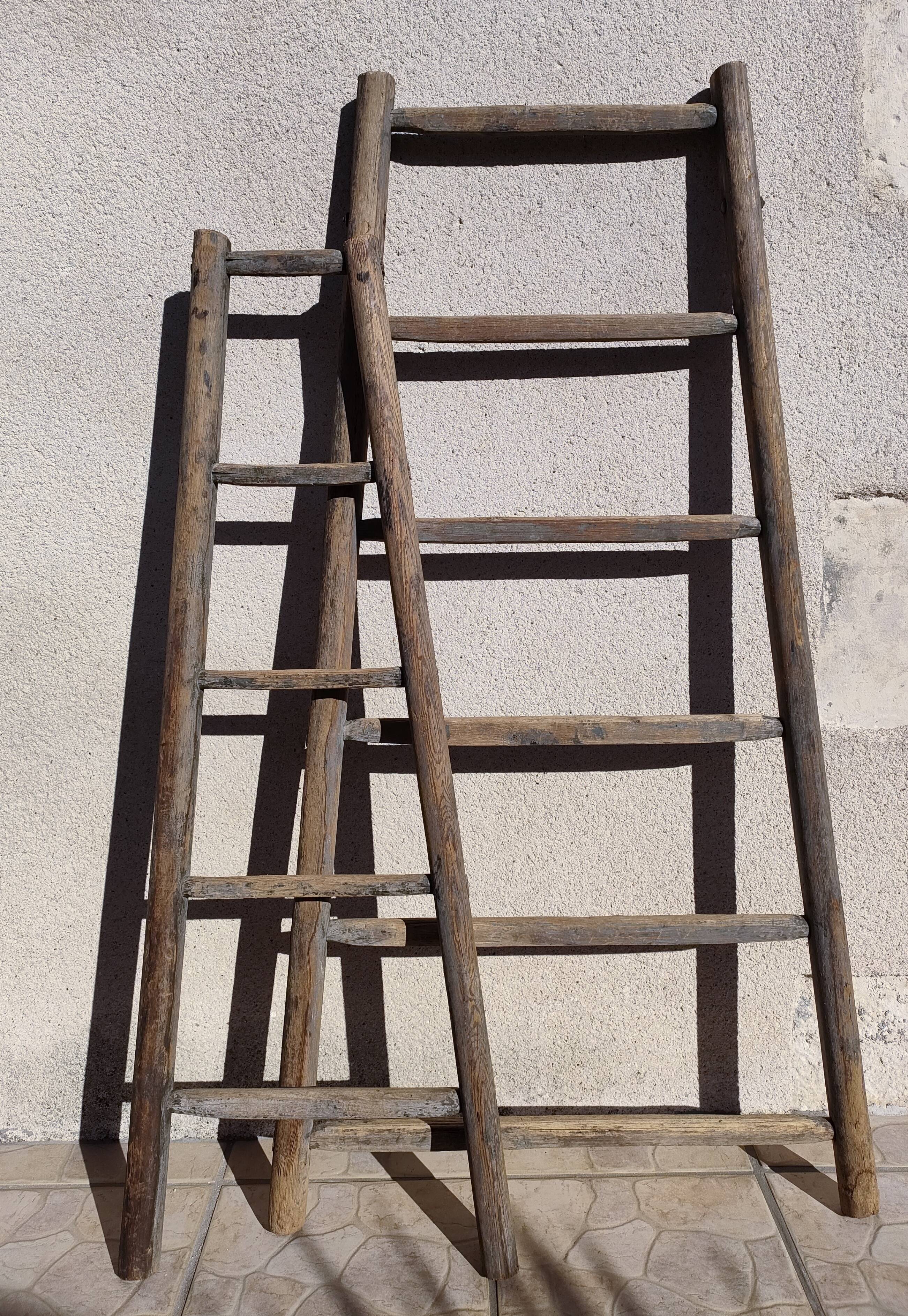 Two weathered wooden ladders H.135 cm
