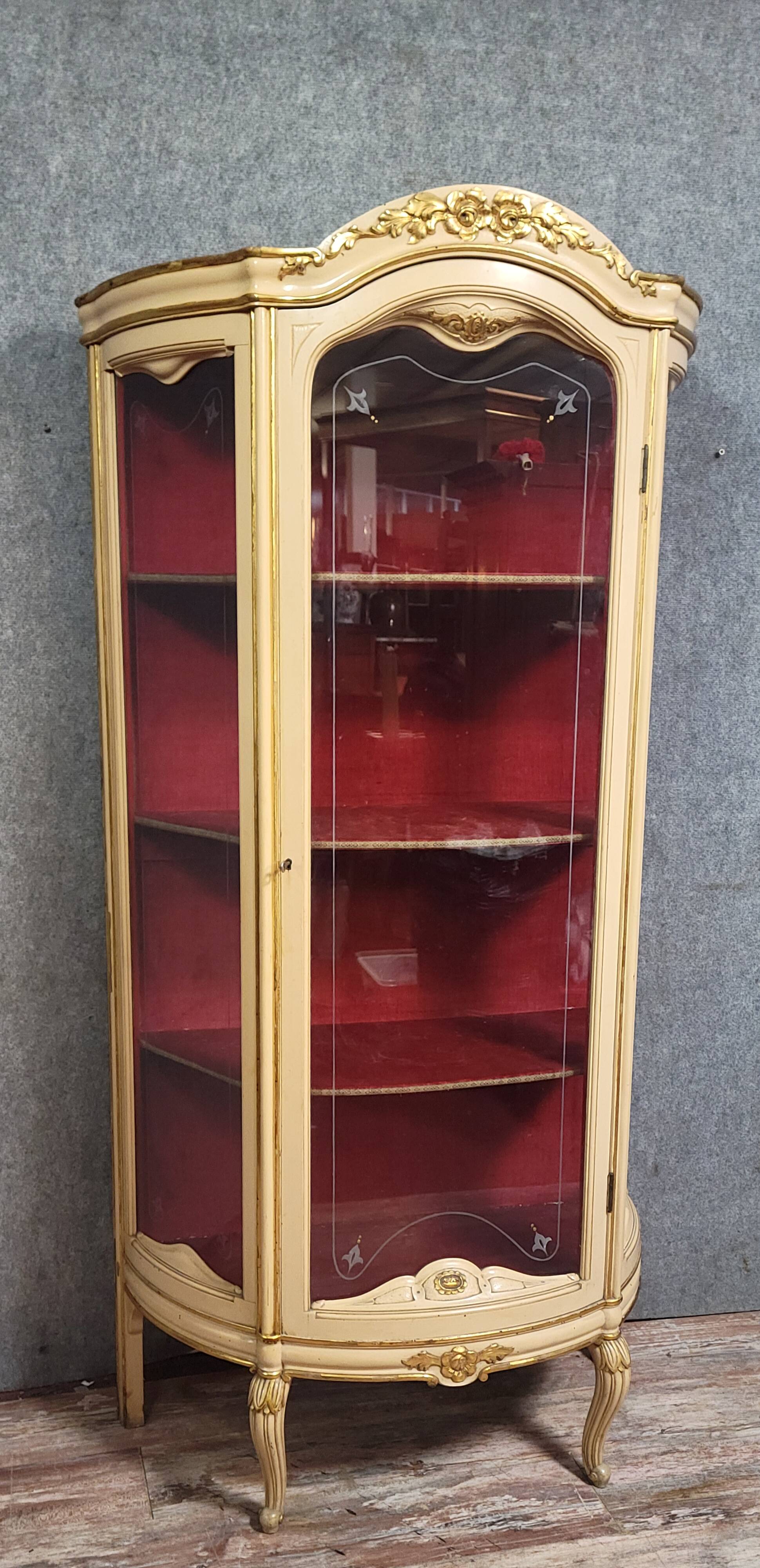 Curved display cabinet in Louis XV style, in cream lacquered wood enhanced with gilding.