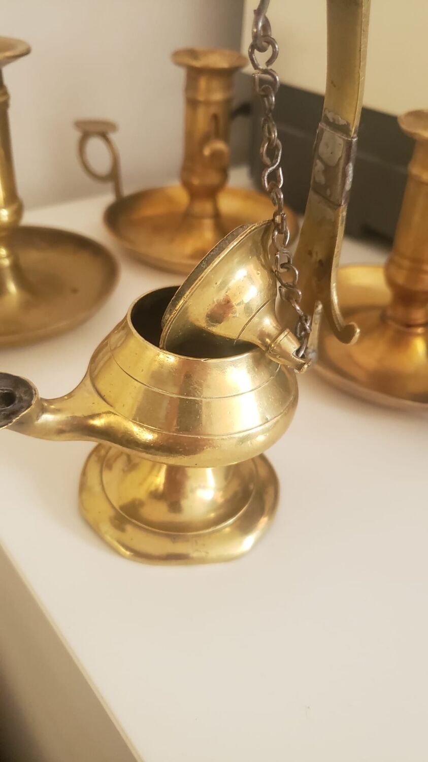 Many candlesticks and a small oil lamp.