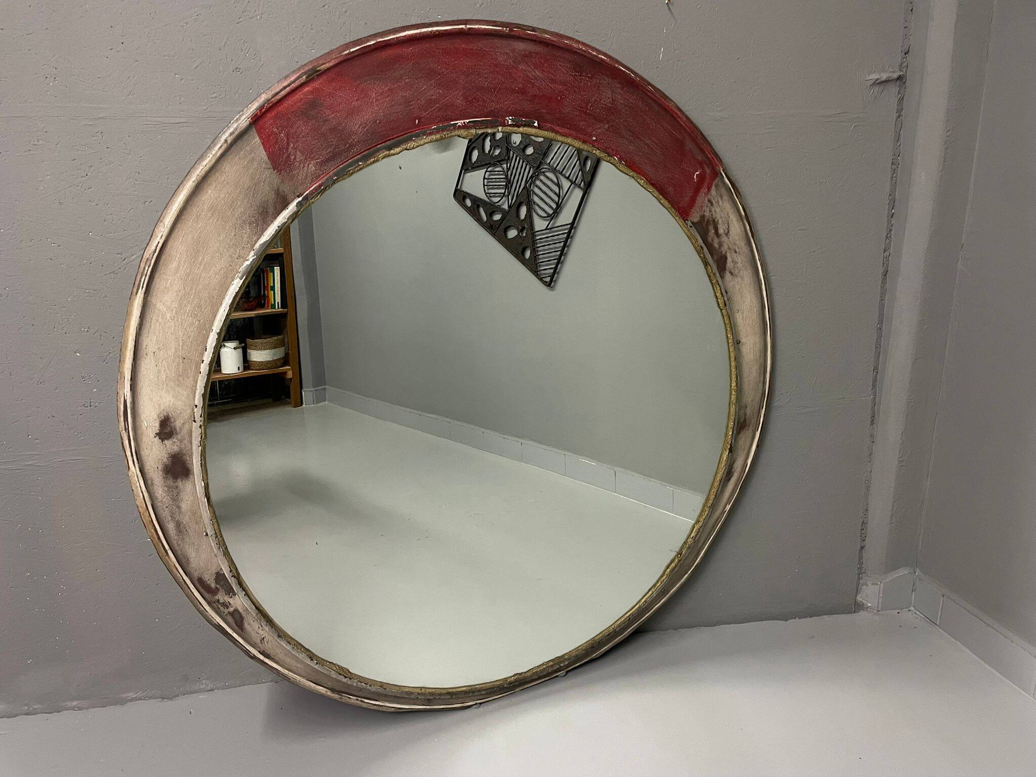Vintage round mirror with an industrial metal frame in a painted finish.
