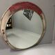 Vintage round mirror with an industrial metal frame in a painted finish.