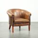 Sheepskin club armchair in a brown colour finished with decorative nails