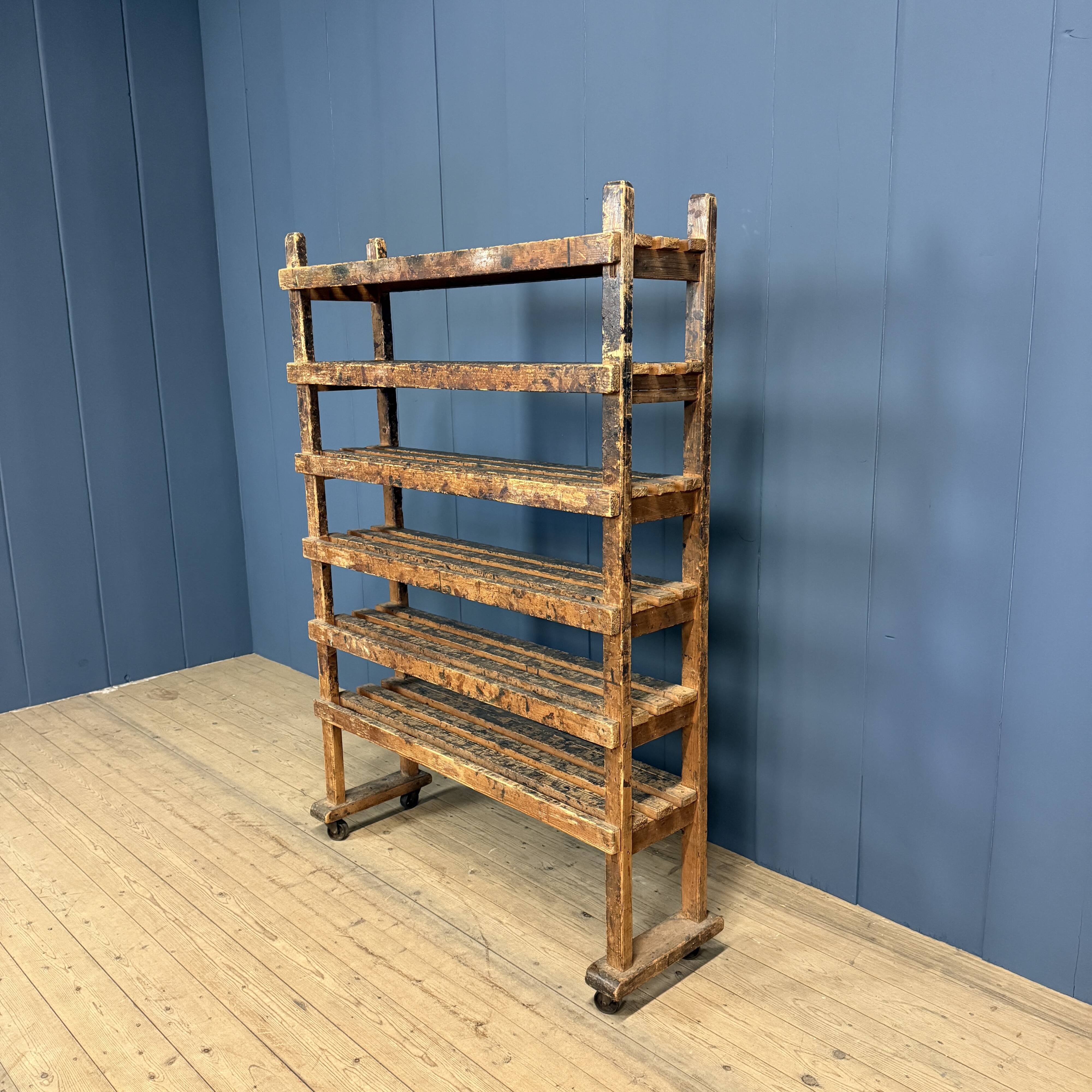 Old wooden workshop shelf with cast iron wheels.