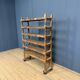 Old wooden workshop shelf with cast iron wheels.