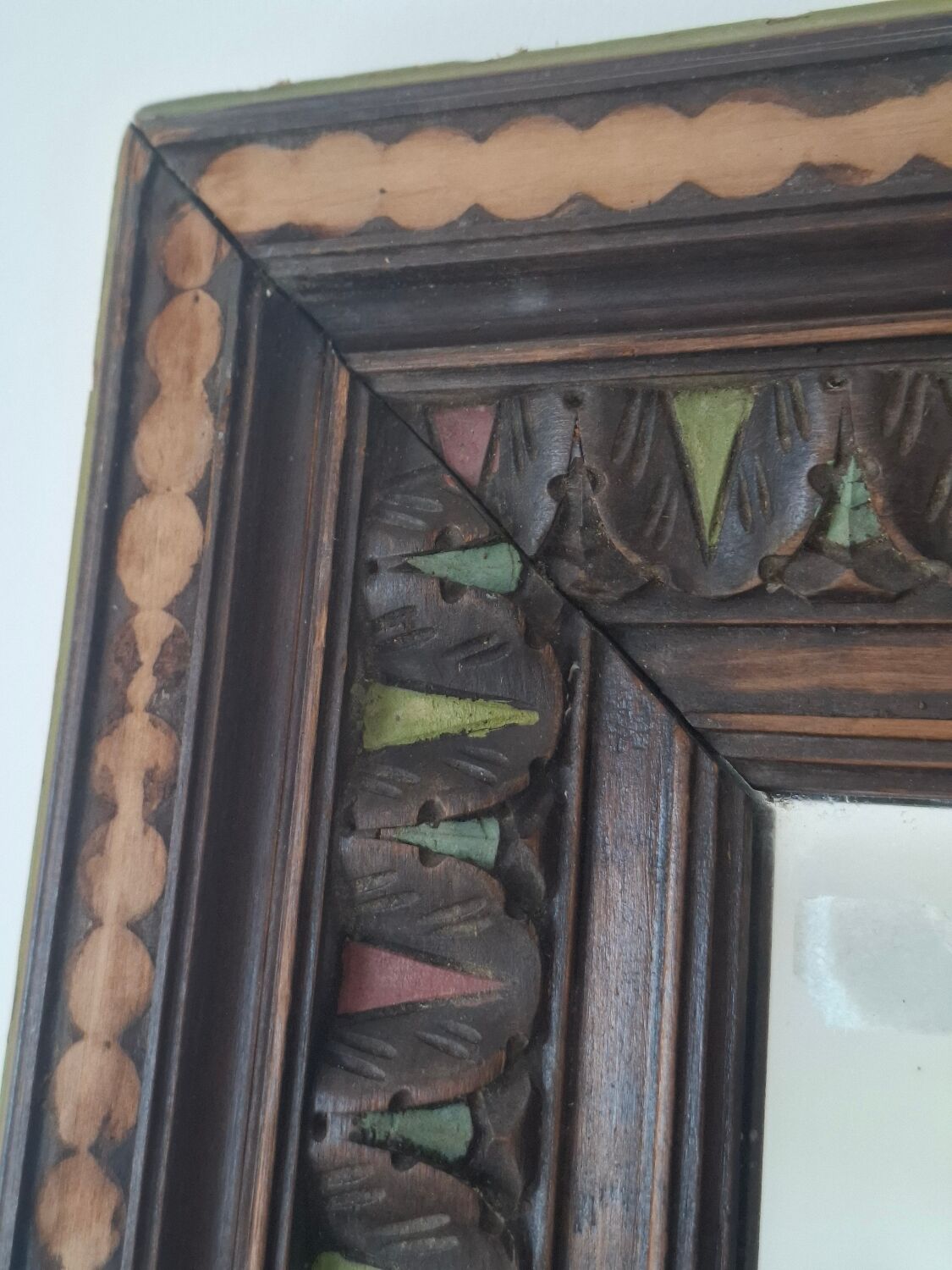 Antique mirror with a carved and painted wooden frame