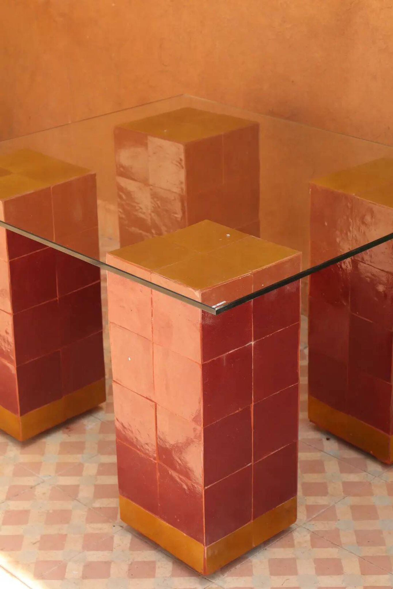 Modern coffee table in burgundy zellige with a tempered glass top.