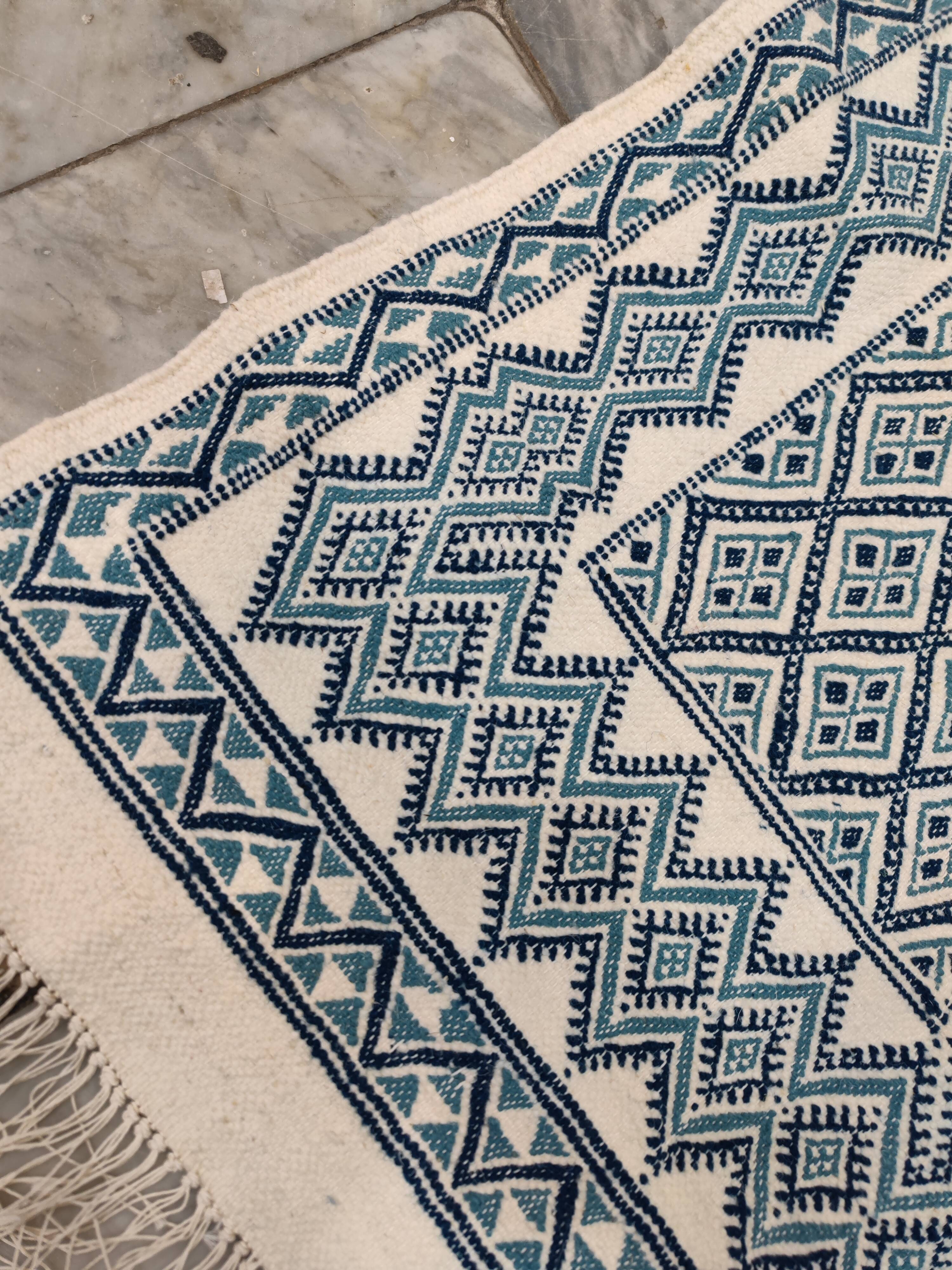 White and blue hand-woven rug in natural wool