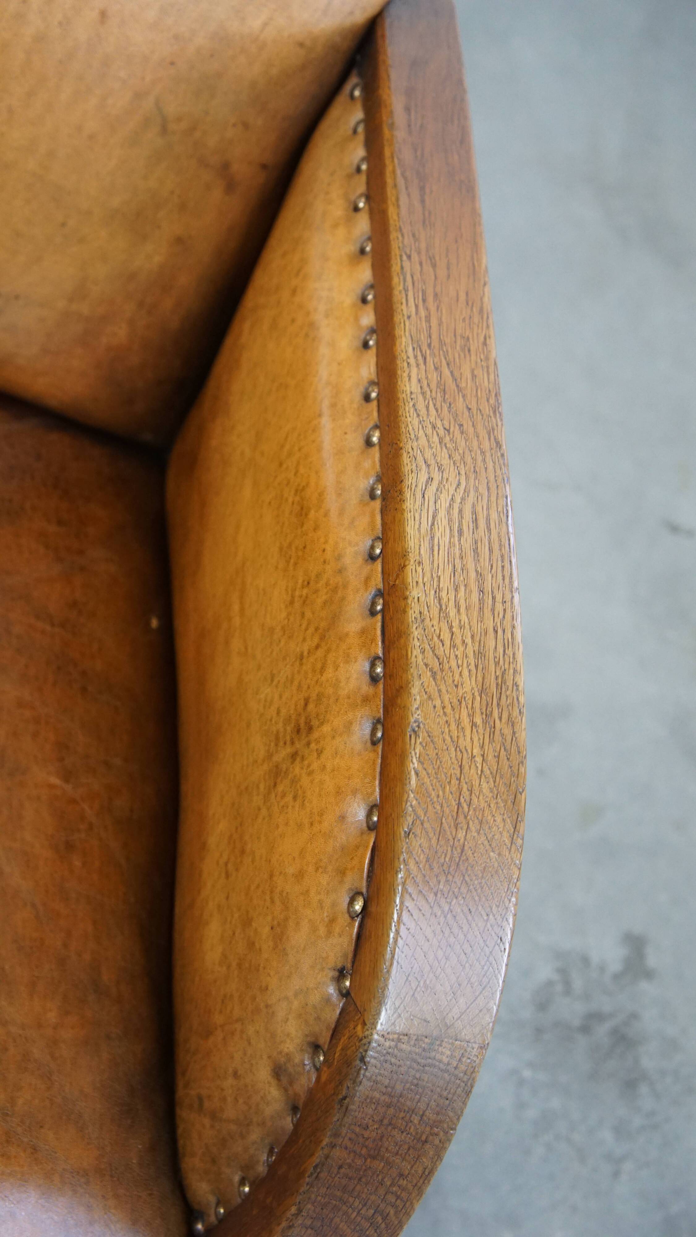 Cognac-colored sheepskin and wooden Art Deco design armchair