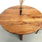 Modernist round table in solid elm, crossed legs.