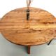 Modernist round table in solid elm, crossed legs.