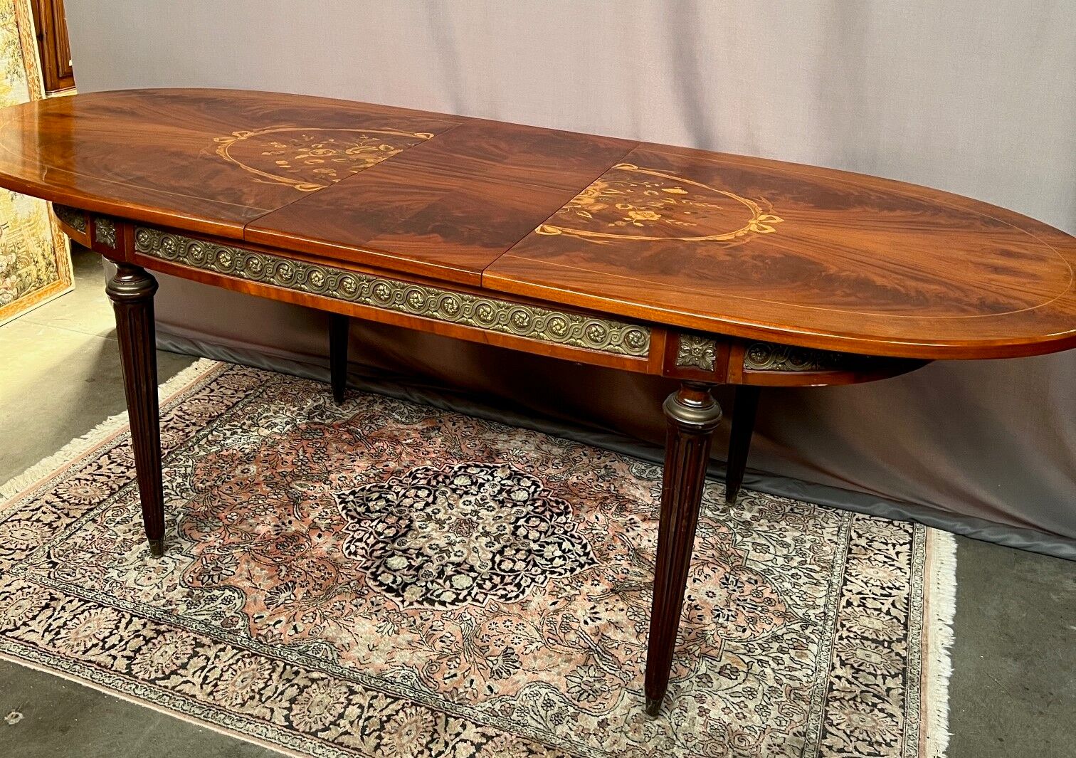 Louis XVI style oval dining table with rosewood marquetry extension mounted in bronze