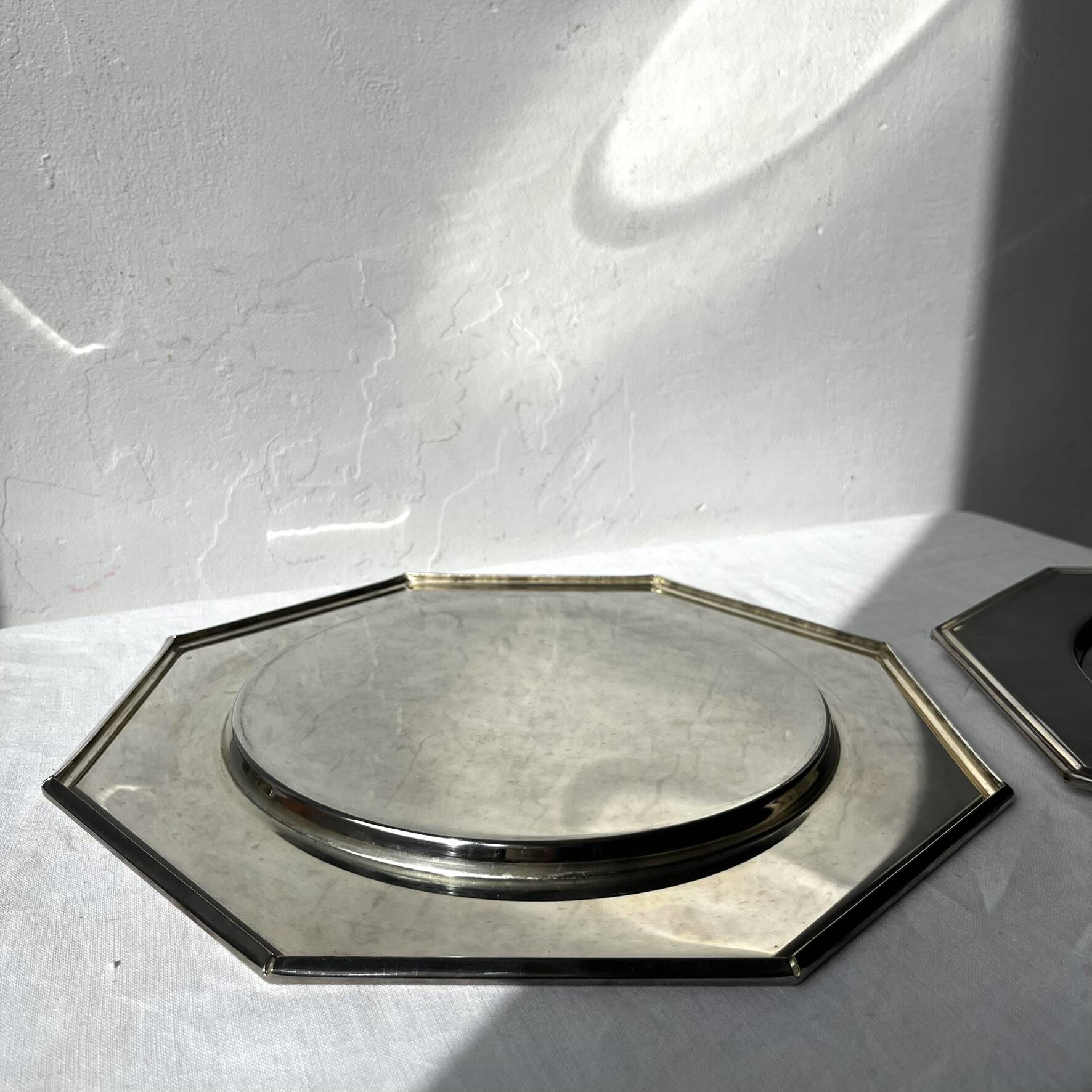 Many octagonal presentation plates in silver-plated metal.