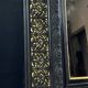19th-century mirror Napoleon III in blackened wood on a gold background.