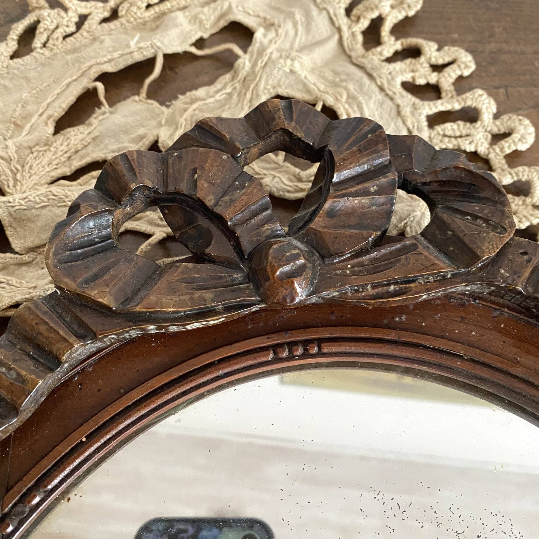 Miroir ovale mercure en bois sculpté décor nœud ruban 37X52