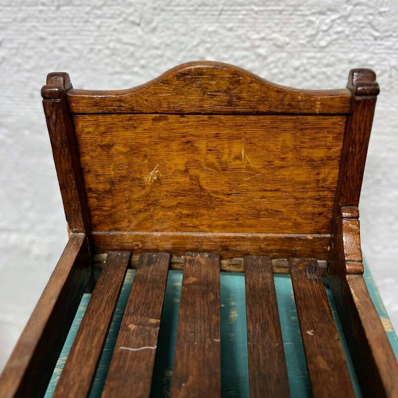 Old doll's bed in varnished wood