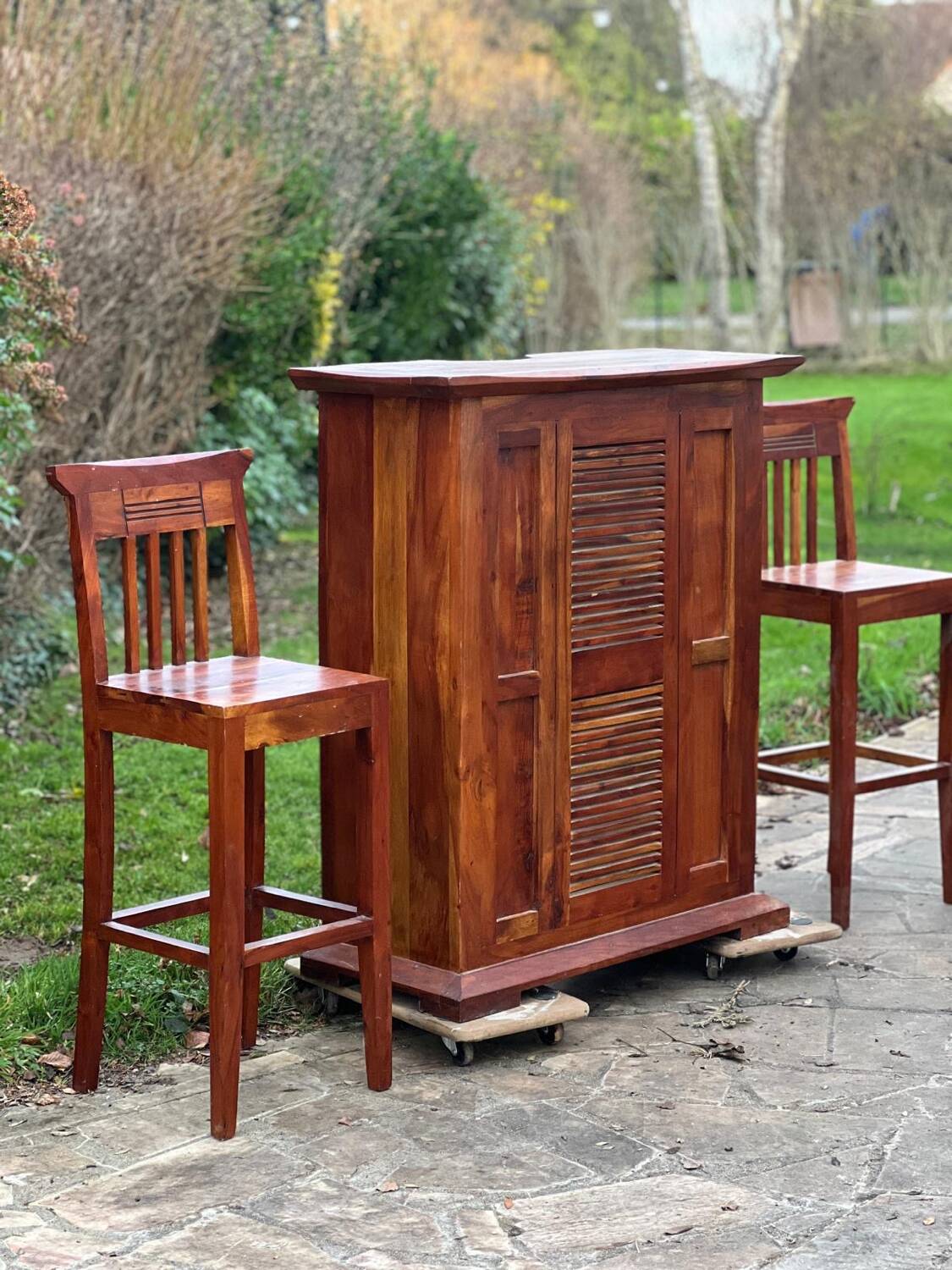 Exotic wood bar with 2 high stools.