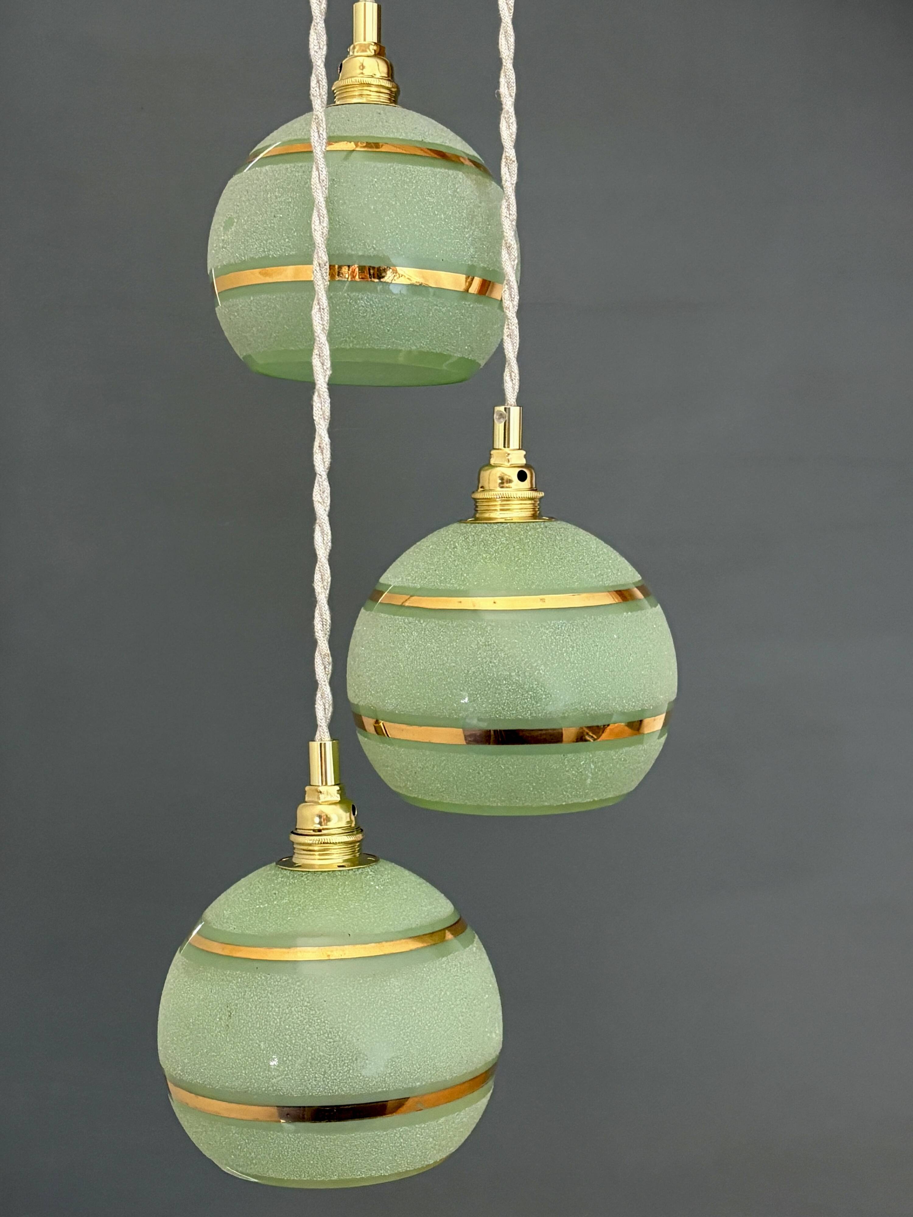 Suspension triple vintage glass globes in frosted green and gold.