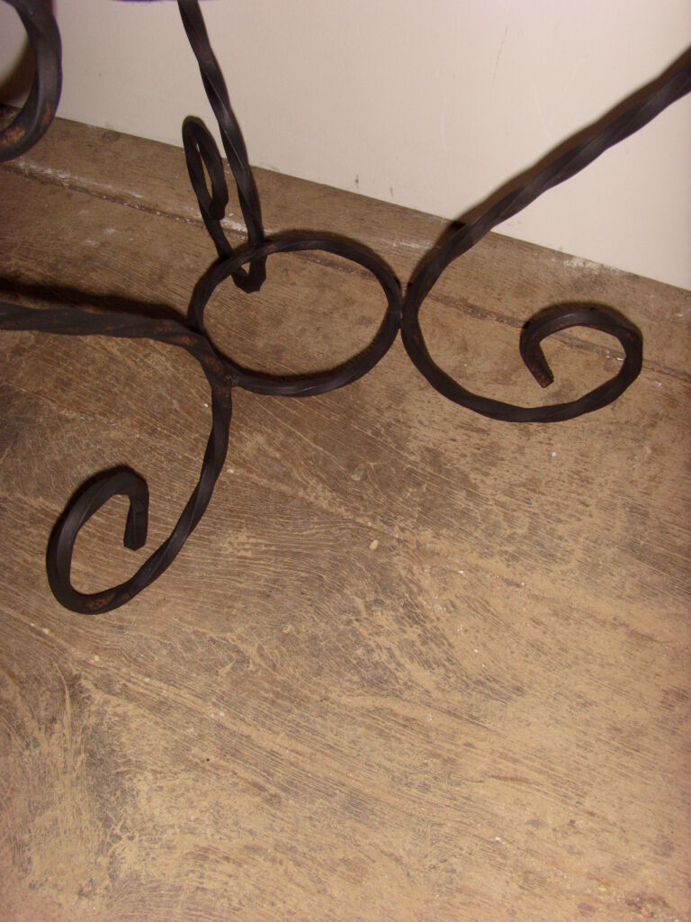 Sellette porte plante en fer forgé noir.