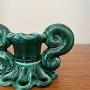 Green ceramic candlestick with curled handles.