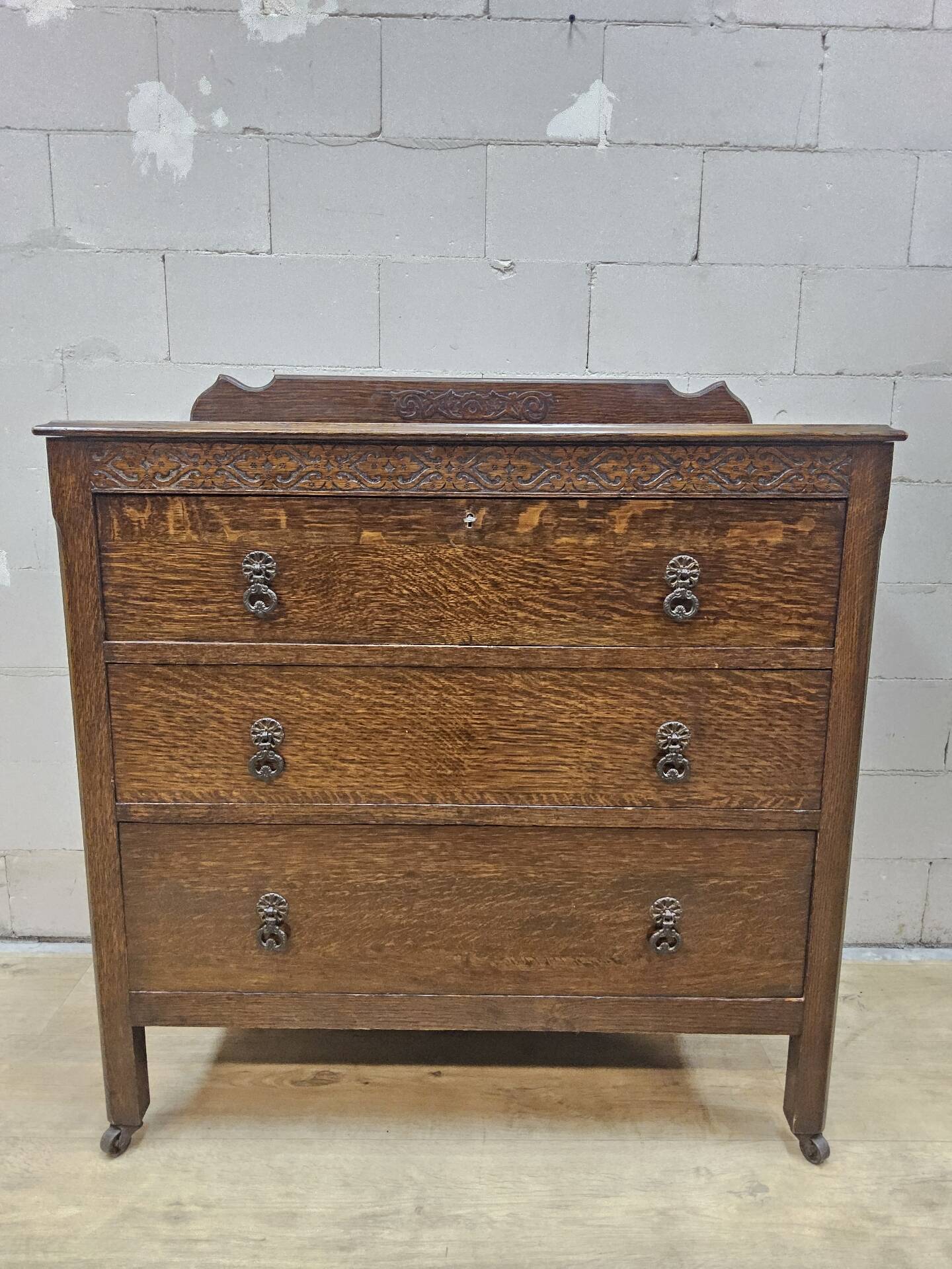Antique chest of drawers on wheels with wood carving (key top drawer)