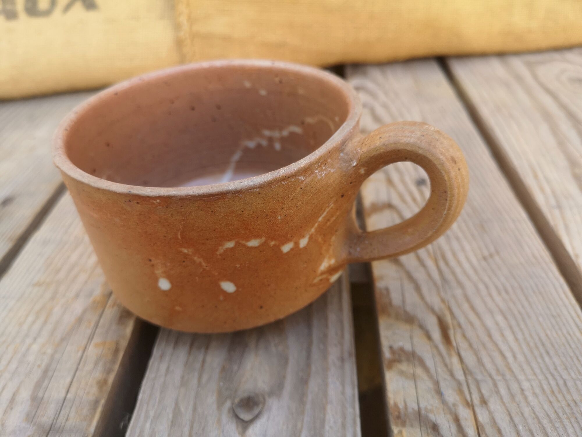 Brown sandstone cup with white spots