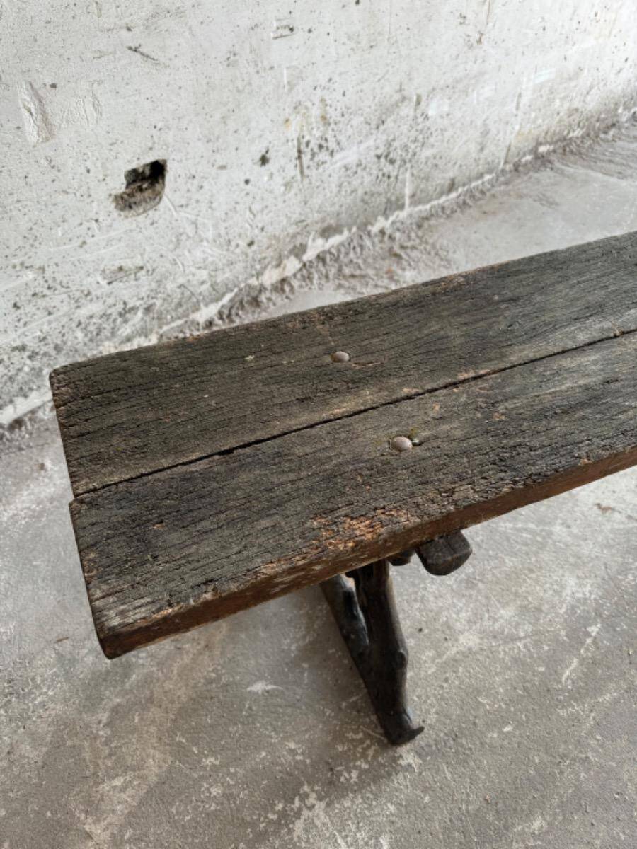 Dark brown wood and black cast-iron antique garden bench with weathered solid-wood seat