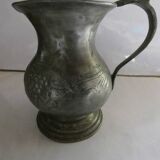 pewter pitcher with handle and bunch of grapes on the pot