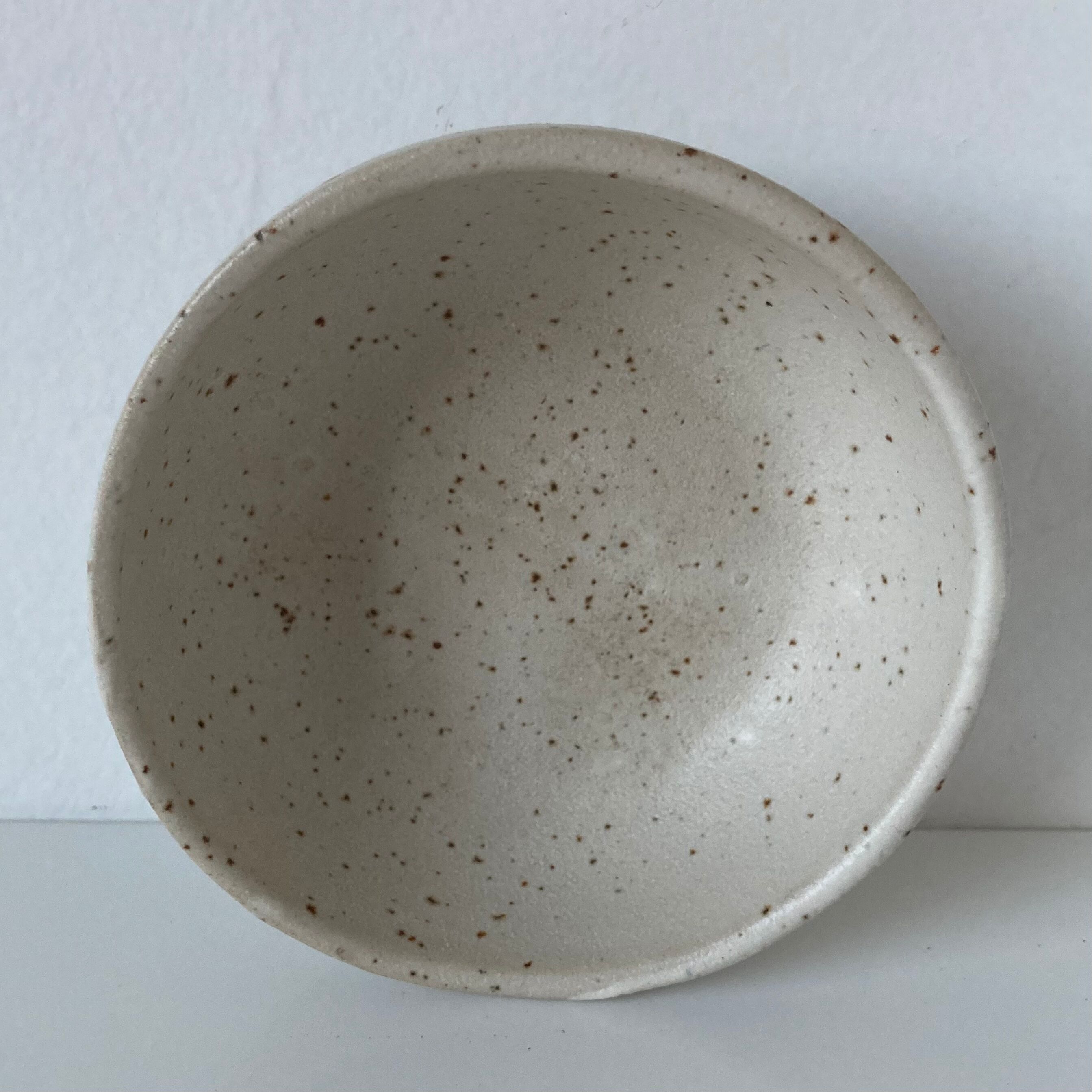 Meeting of three artist's ceramic objects including two pots and a cream covered bowl