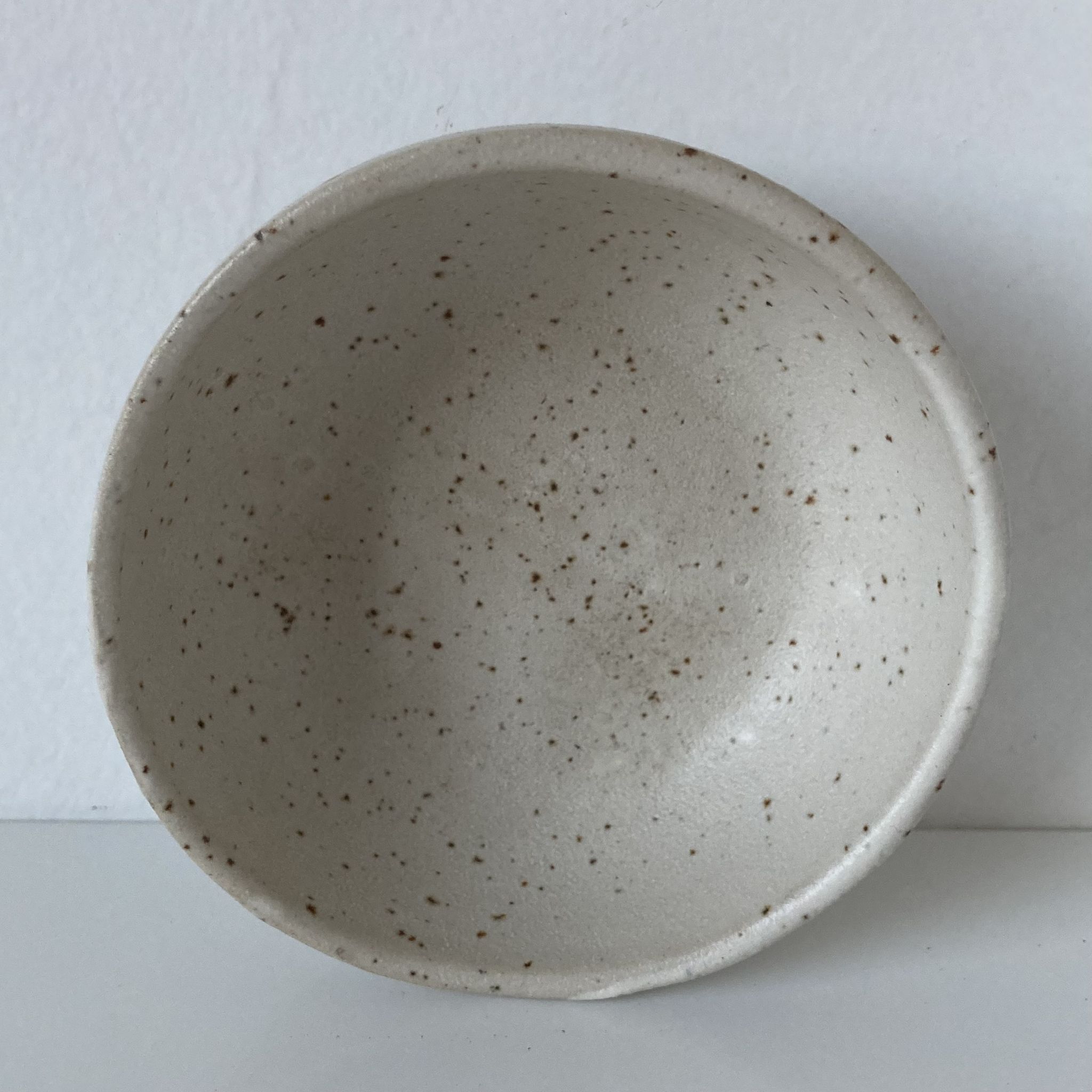 Meeting of three artist's ceramic objects including two pots and a cream covered bowl