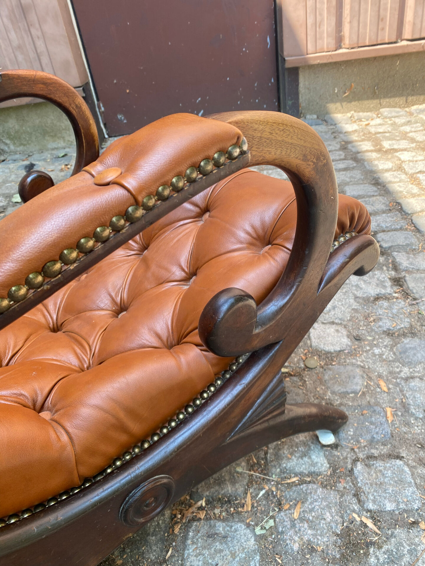 Chesterfield armchair in leather and carved solid wood