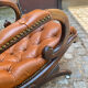Chesterfield armchair in leather and carved solid wood