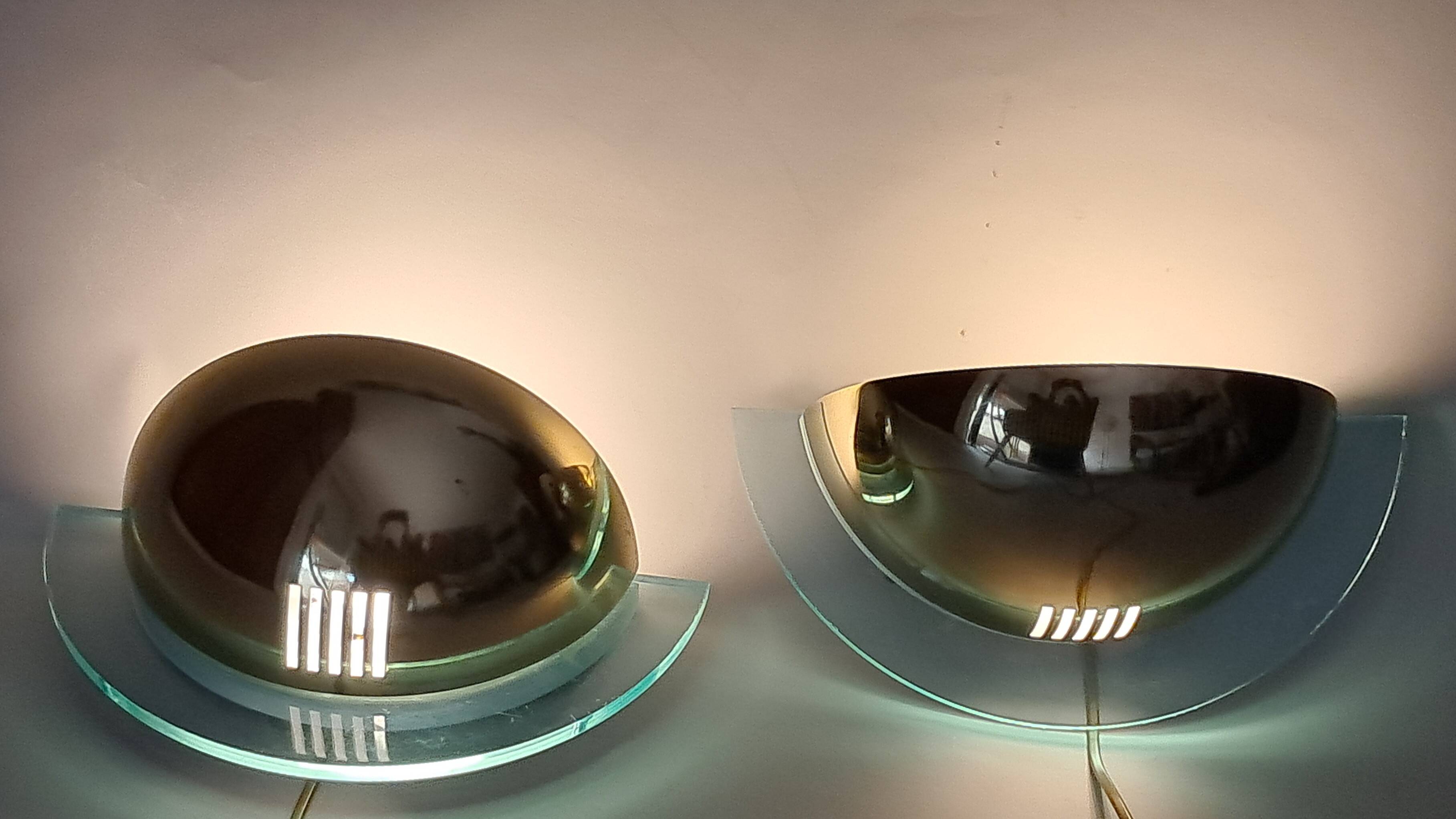 Pair of gold metal and plexiglass wall lights, circa 1980.