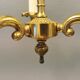 Older brass alloy chandelier with three light sources.