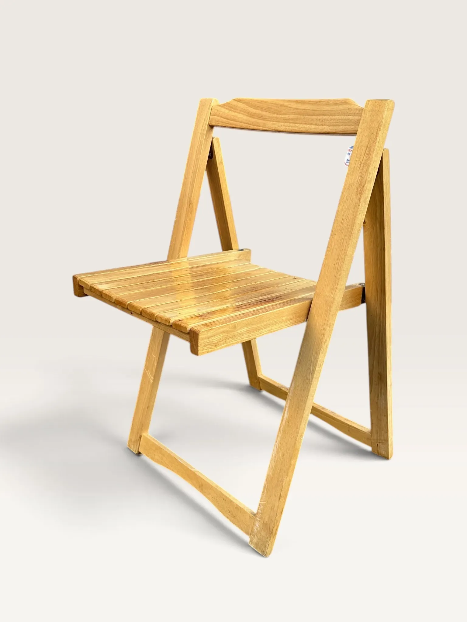 Blonde wooden folding chair in the style of Aldo Jacober.