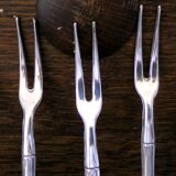 Five silver-plated metal appetizer forks with bamboo-style handles