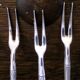 Five silver-plated metal appetizer forks with bamboo-style handles