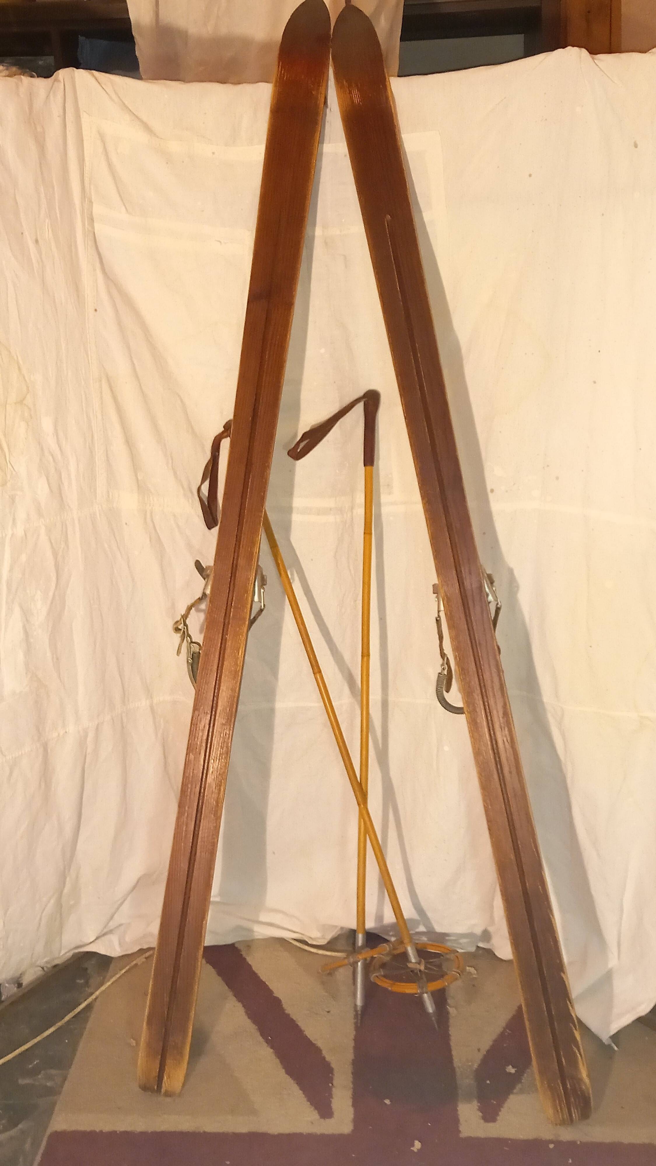 pair of vintage wooden Skis and their bats.
