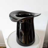 Large black glass vase topped with a 70s hat