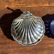Vintage silver-plated shell butter dish with blue bowl.