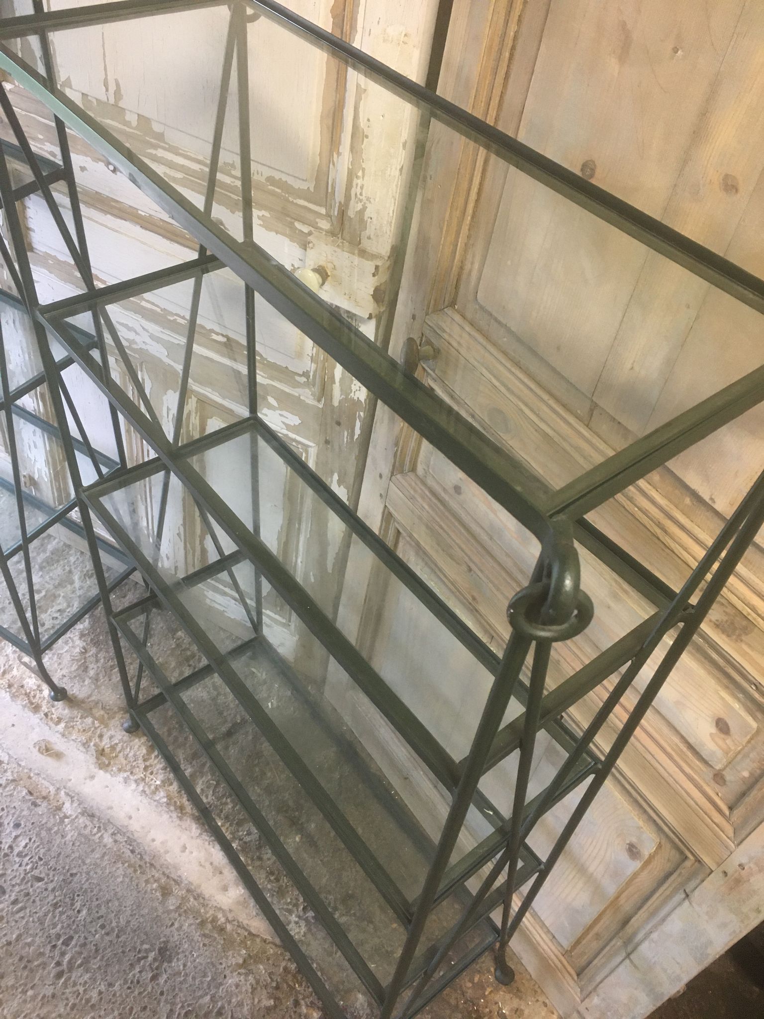 Pair of wrought iron and glass bookshelf shelves.