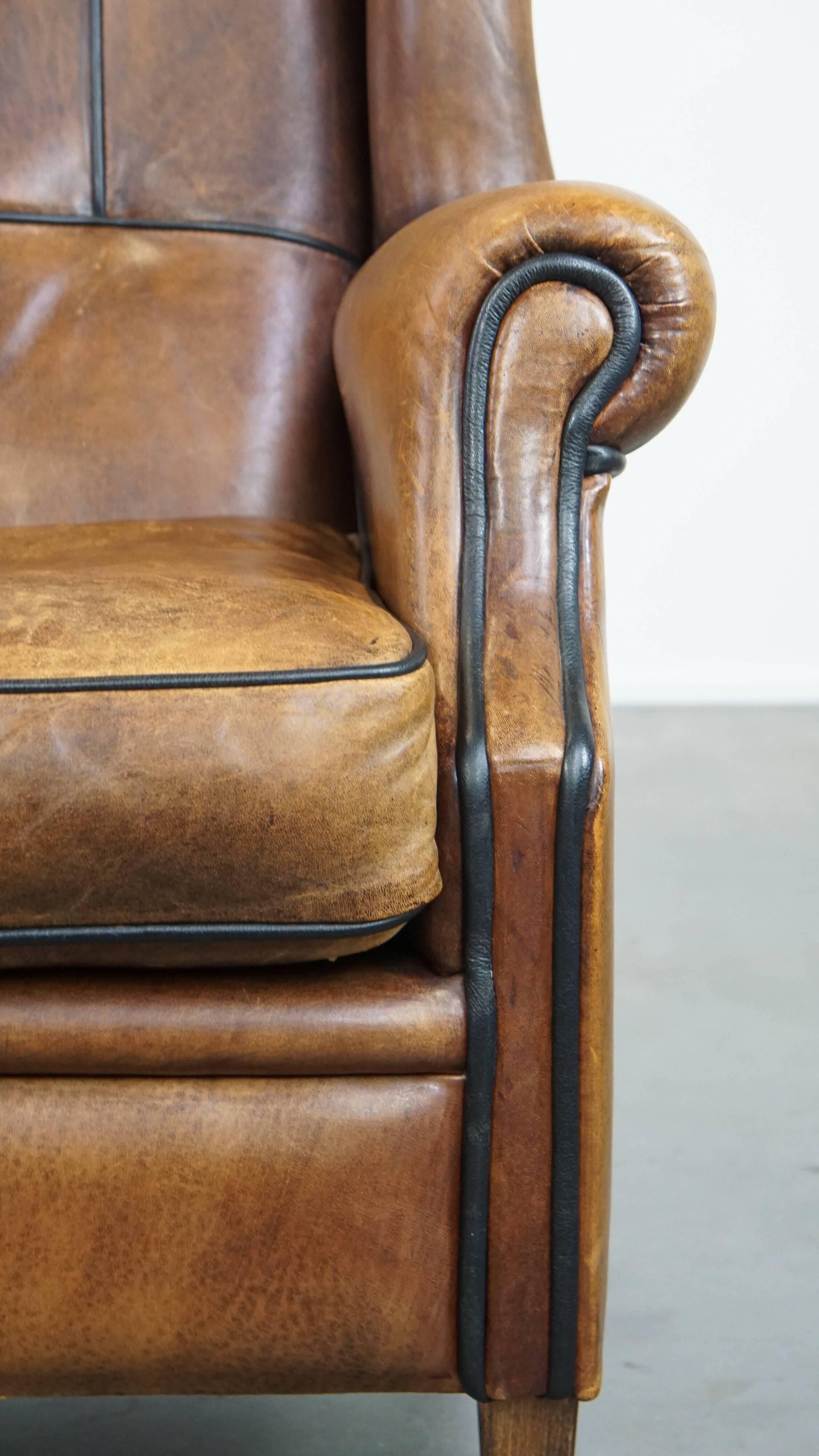 Sheep leather wingback chair finished with black piping