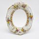 Antique porcelain mirror from Dresden with relief flowers and rococo decoration.