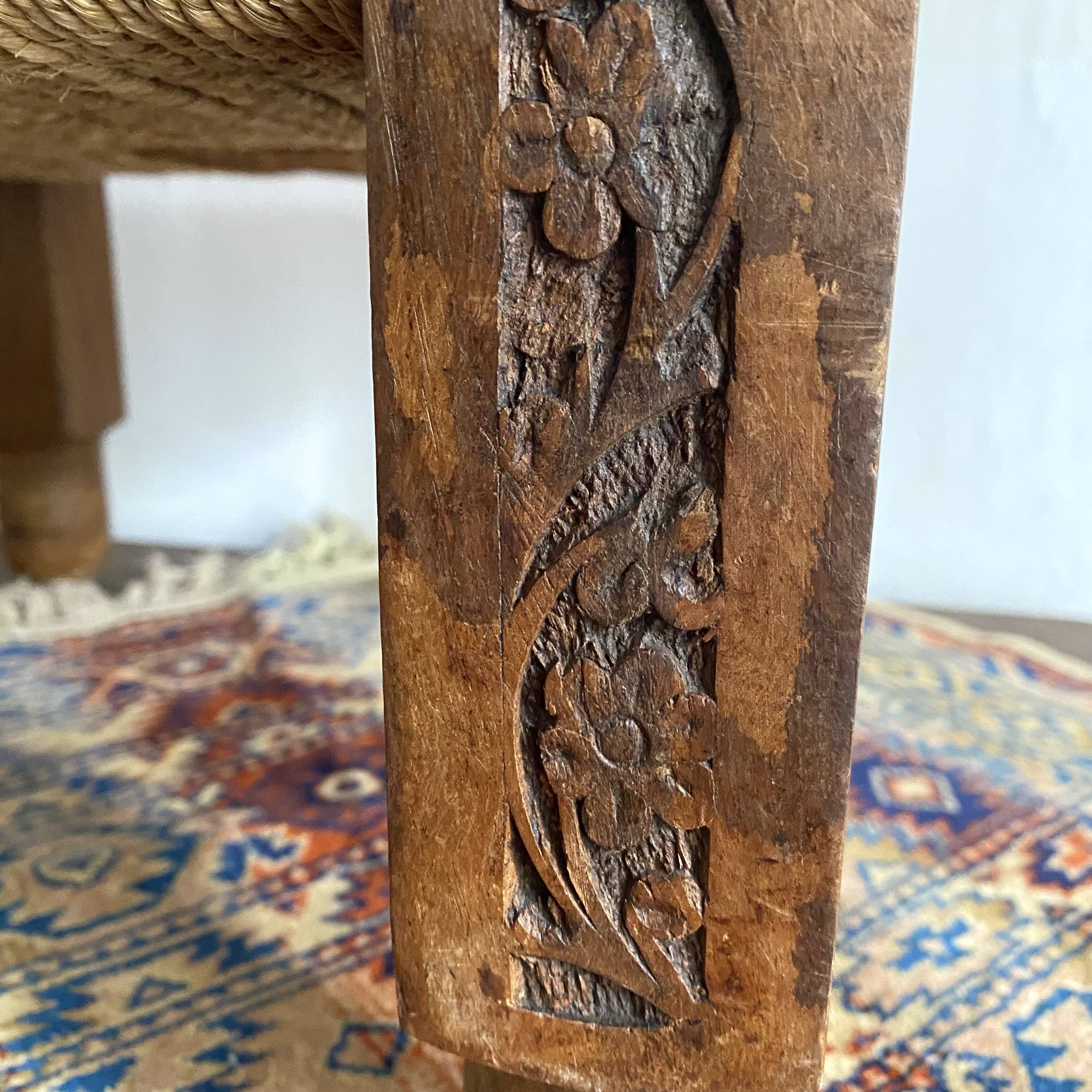 Low stool with carved wood and braided cord.