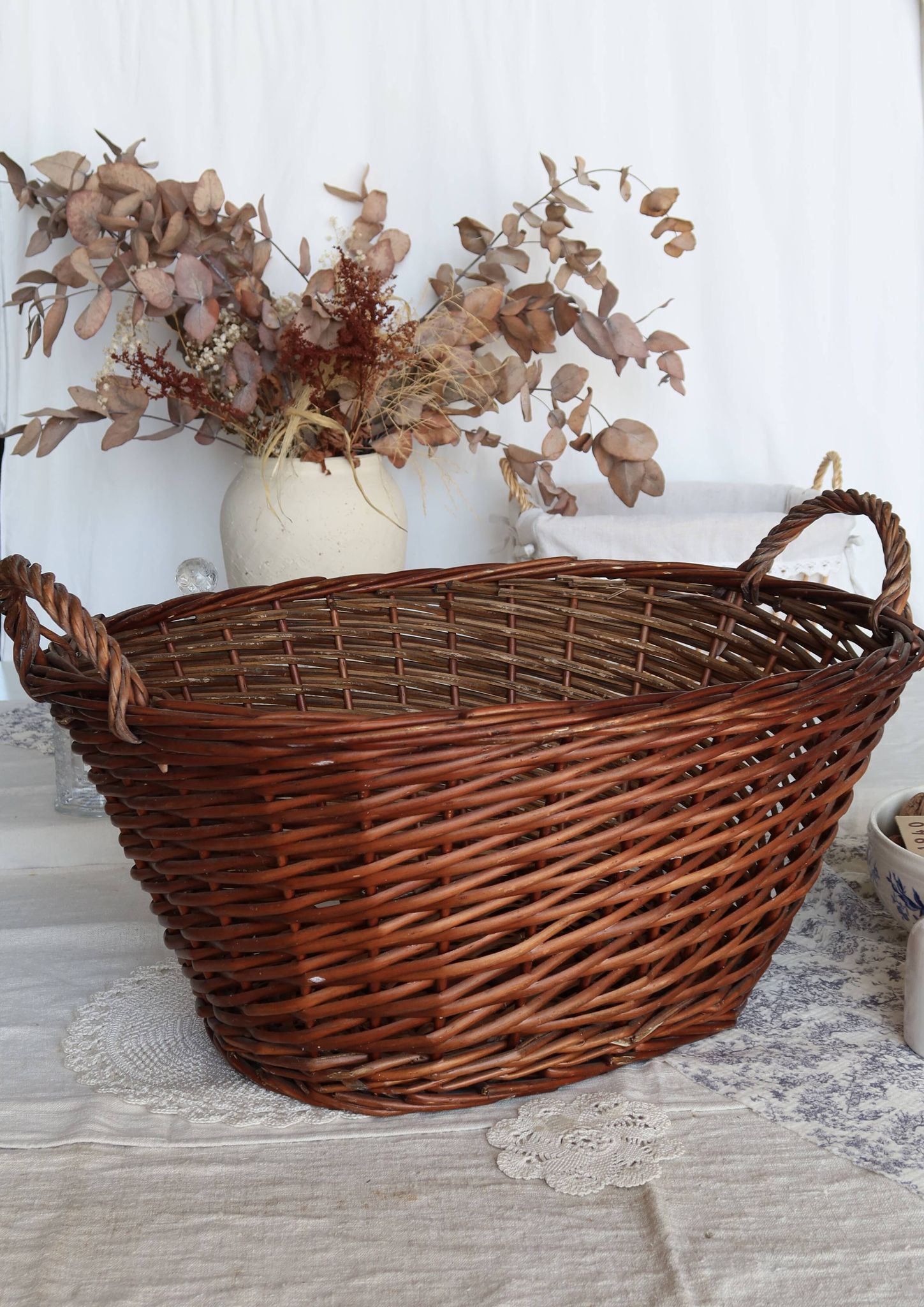 Grand panier en osier foncé vintage avec anses