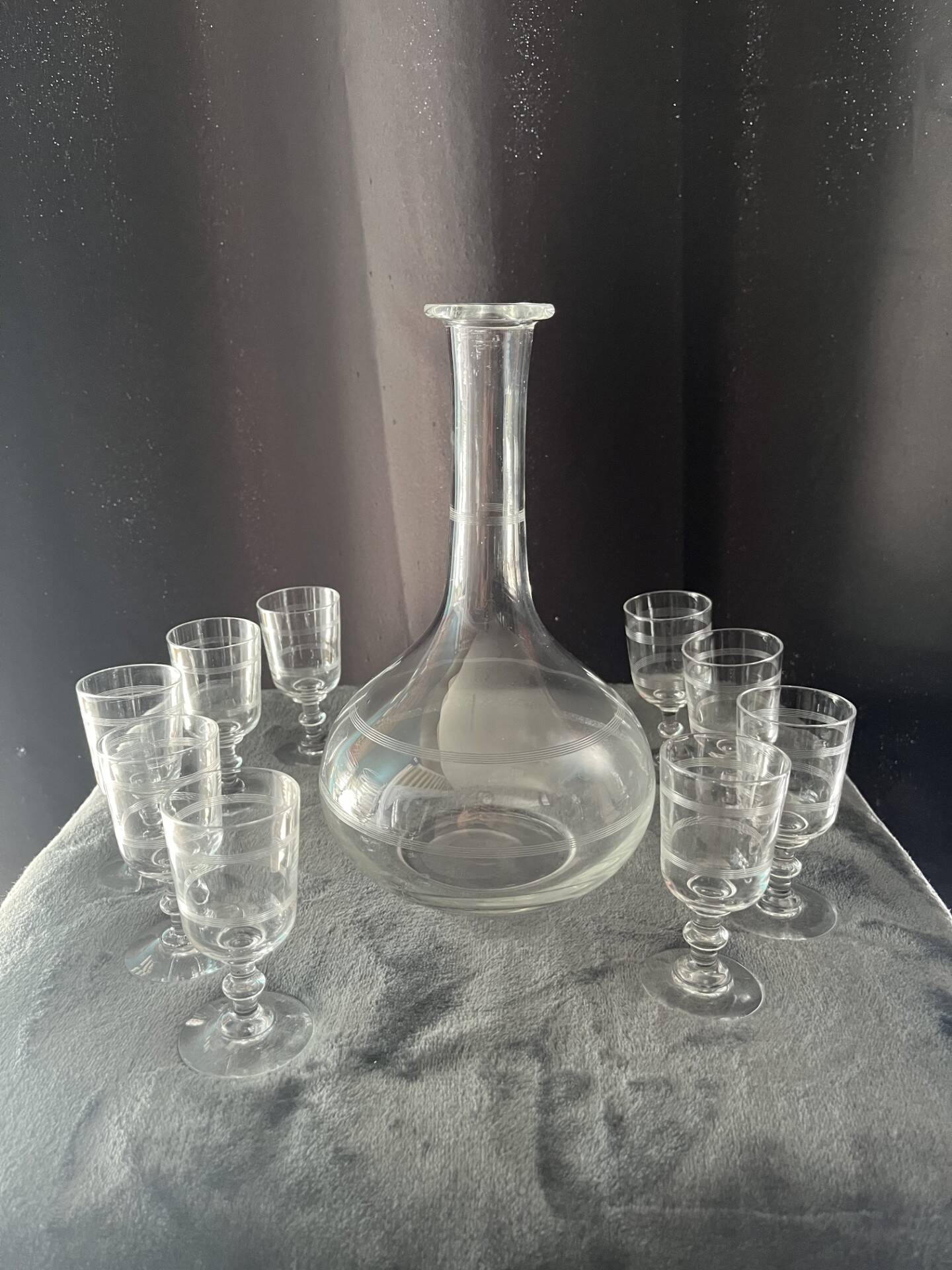 Service of an engraved art deco liqueur - captain's decanter and 9 matching glasses.