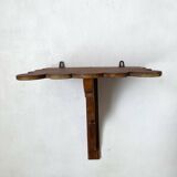 Antique wall shelf with a scalloped edge.