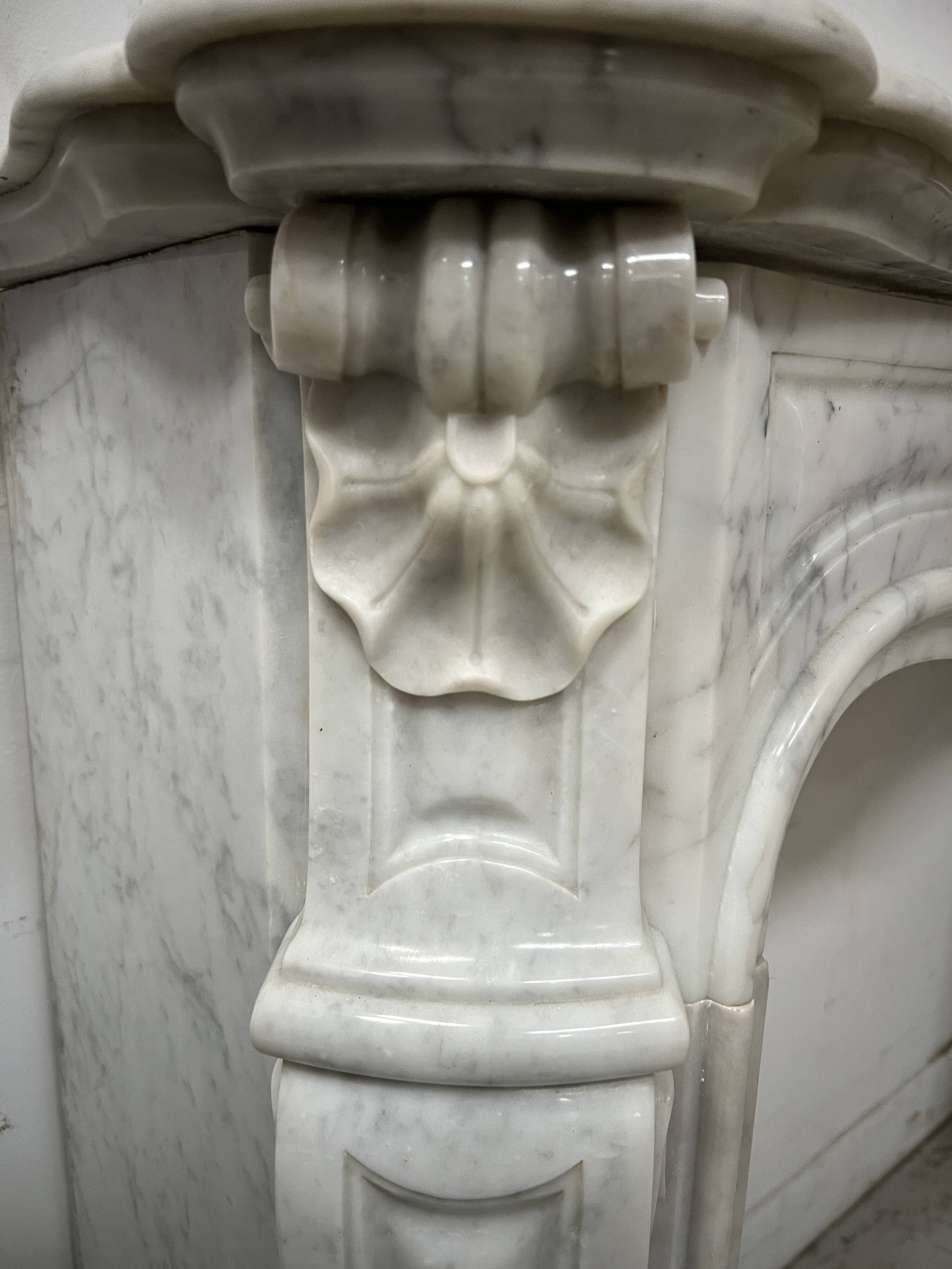 Louis XV style fireplace in veined white marble, 20th century.