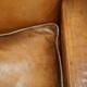 Three-seater Art Deco style leather sofa with feather cushions.